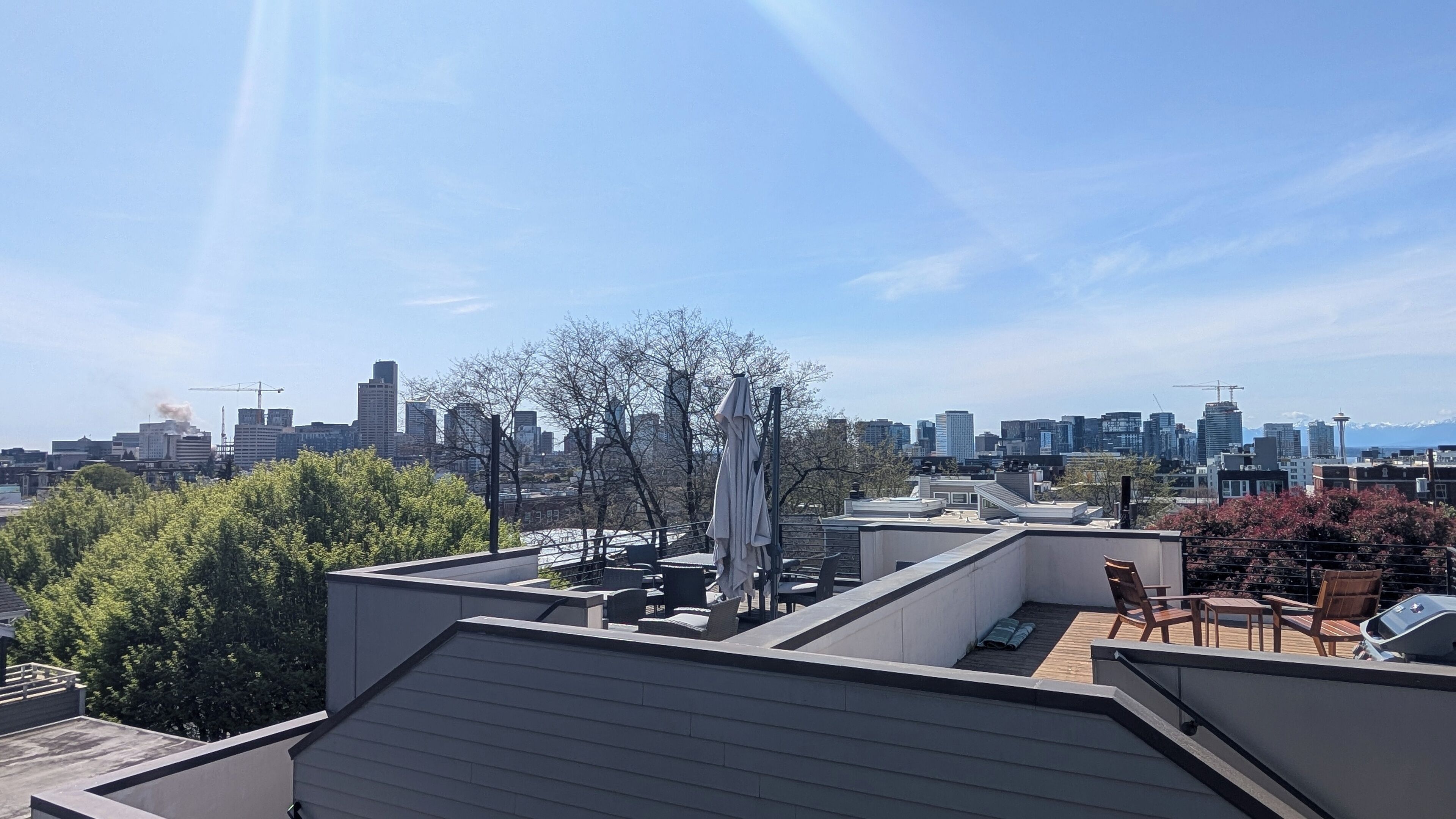 En tagterrasse med udsigt over bybilledet, inklusive en bygningskran og et Space Needle.