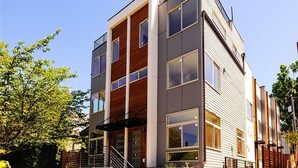 A modern multi-story building with large windows and a wooden facade. - Rooftop Views of the Space Needle & City (Seattle)