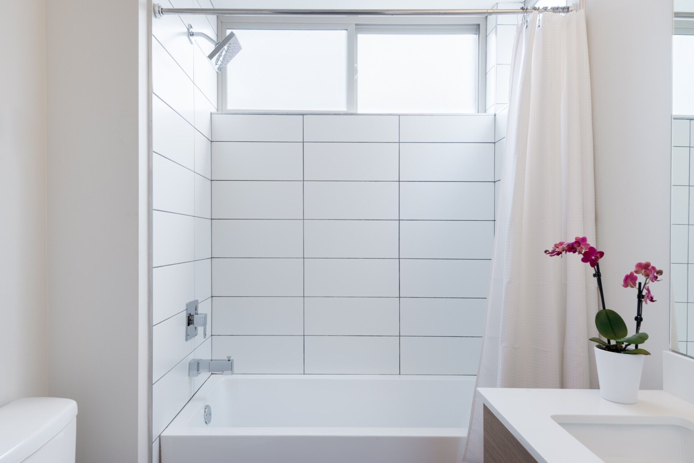 Une salle de bain moderne avec une baignoire blanche, des toilettes et un espace douche.