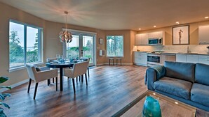 Una cocina moderna con zona de comedor, ventanas amplias y un rincón de estar acogedor.
