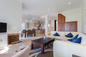 A modern living room with a fireplace, a sofa set, a coffee table, and a TV.