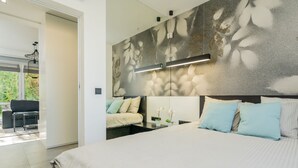 A modern bedroom with a large bed, a sofa, and a dining area. - Premium Apartments in Wadowice (Wadowice)