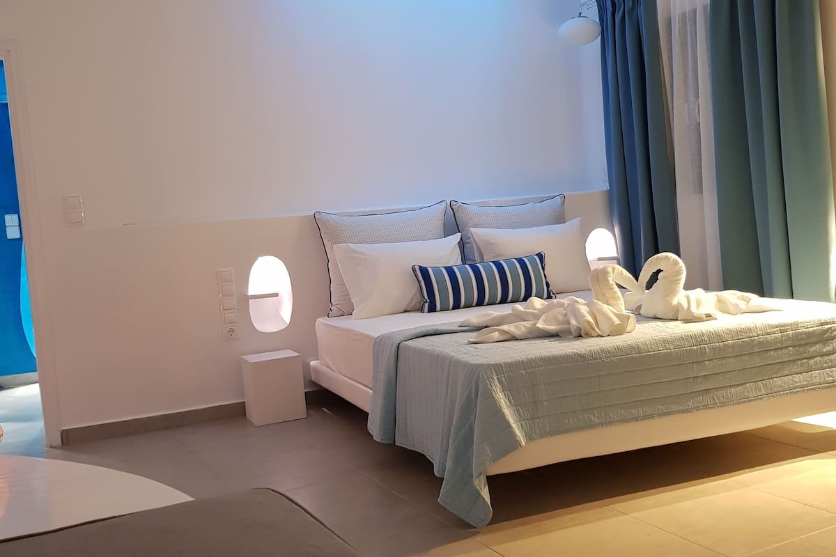 A modern bedroom with a bed, bedside tables, and a ceiling light fixture.