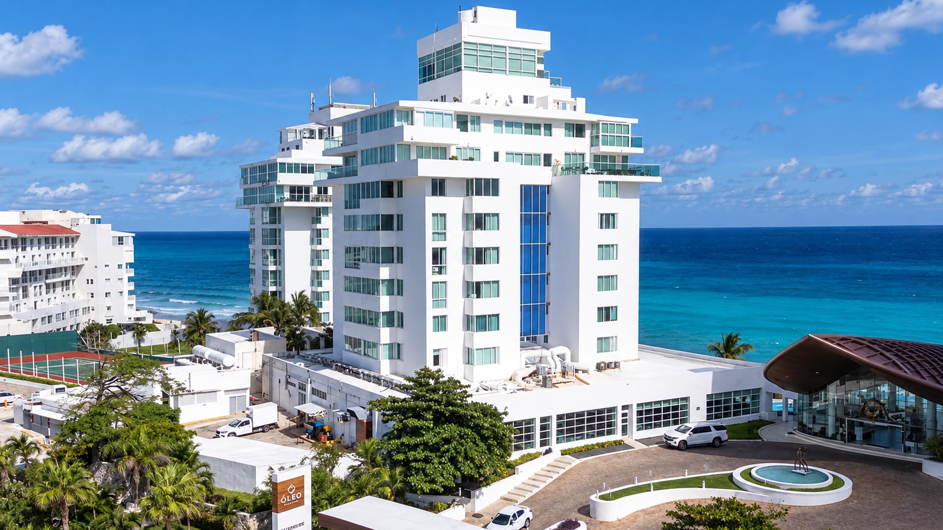 Un hôtel moderne à plusieurs étages, doté d’une piscine et offrant une vue sur l’océan.