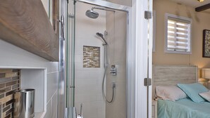 A bathroom with a shower, toilet, and sink.