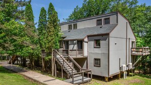 A two-story house with a balcony, a staircase, and a deck.