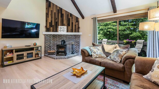 A living room with a fireplace, a television, and a sofa with patterned cushions.