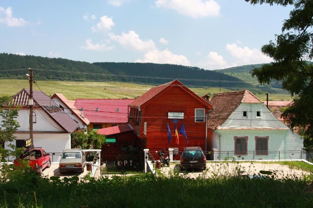 A rural setting with a red barn, a white building with a red roof, and a small white structure with a green roof.