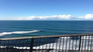 A coastal view with a wooden railing, ocean waves, and a clear sky. - Jan Juc Beach Break - Walk to Beach, Pet Friendly (Jan Juc)