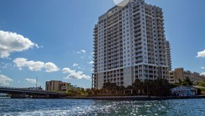 A tall hotel with multiple floors and balconies, situated near a body of water with a bridge in the foreground. - Shorecrest Miami Bay (Miami)