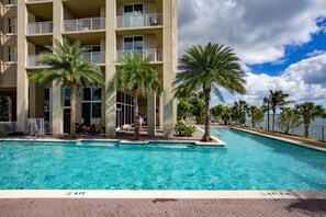 A swimming pool with a 4ft depth marker, surrounded by palm trees and a building with balconies. - Shorecrest Miami Bay (Miami)