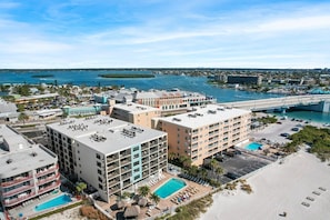 A beachfront hotel with multiple buildings, a swimming pool, and a beach area.