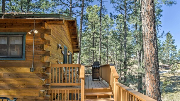 A wooden cabin with a deck, a window, and a grill. - Ruidoso Log Cabin Retreat - Peaceful & Convenient (Ruidoso)