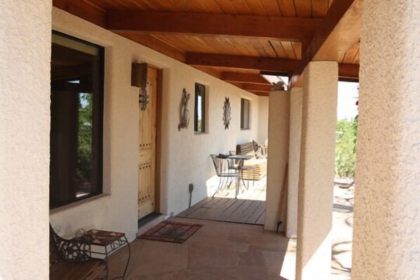 A covered patio area with a wooden ceiling, a table and chairs, and a view of the outdoors. - Beautiful home with pool, private, close to UA & Downtown, arts. Great prices! (Tucson)