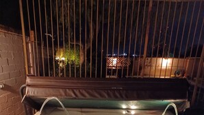 A hot tub with two jets, surrounded by a metal fence and a brick wall. - Beautiful home with pool, private, close to UA & Downtown, arts. Great prices! (Tucson)