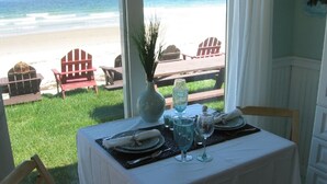 A table set for two with a view of the beach. - Moody Beach Front Studio Cottage WIFI (Wells)