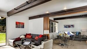 Una sala de estar moderna con sofá, mesa de centro y zona de comedor.