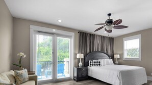 A bedroom with a bed, two bedside tables, a ceiling fan, and a large window with curtains. - Spacious Rental, Three Story Townhome, Close to Pool (Miramar Beach)