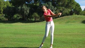Une personne jouant au golf sur un terrain verdoyant, avec des arbres en arrière-plan.