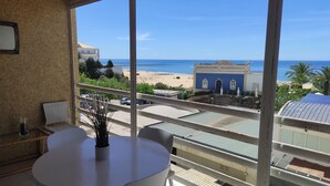 Een balkon met uitzicht op het strand en een gebouw met blauwe tegels.