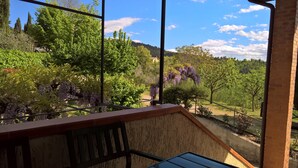 A balcony with a view of a garden and trees.