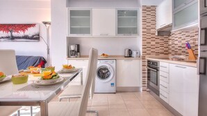 A compact kitchen with a washing machine, a coffee maker, and a microwave. - LOVELY 2 BEDROOMED APARTMENT NEXT TO THE BEACH (Arona)