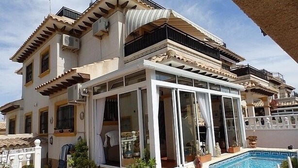 A multi-story house with a swimming pool, large windows, and outdoor seating. - Town House With Private Pool ,Good WiFi. Short walk to Villamartin Plaza (alicante)