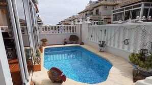 A small, rectangular swimming pool with a decorative edge, surrounded by a white fence and potted plants. - Town House With Private Pool ,Good WiFi. Short walk to Villamartin Plaza (alicante)