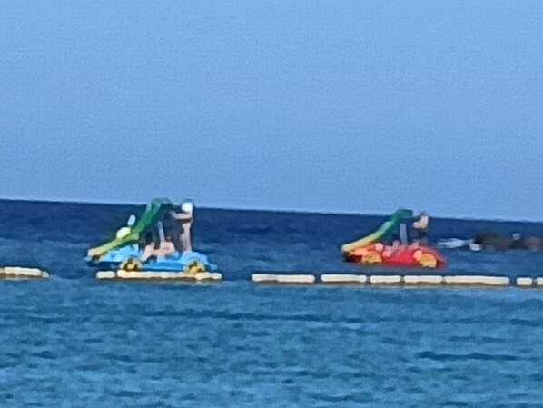 Eine Reihe farbenfroher Wasserfahrzeuge auf ruhiger See.