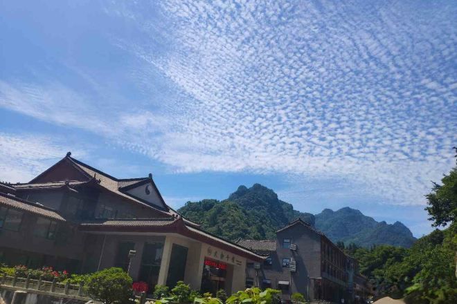Edificio tradicional con un letrero, una montaña al fondo y cielo despejado.