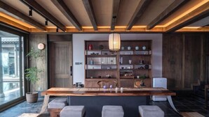 A modern kitchen with a wooden island, built-in shelves, and a large window. - Tai Chi Hotel (Shiyan)