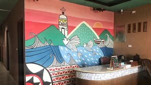 A reception area with a colorful mural, a reception desk, and a view of the hallway. - Two Fish (Lanyu)