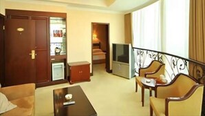 A hotel room with a living area, a TV, a small kitchenette, and a balcony with a railing. - Kunshan Yuxing Hotel (Suzhou)
