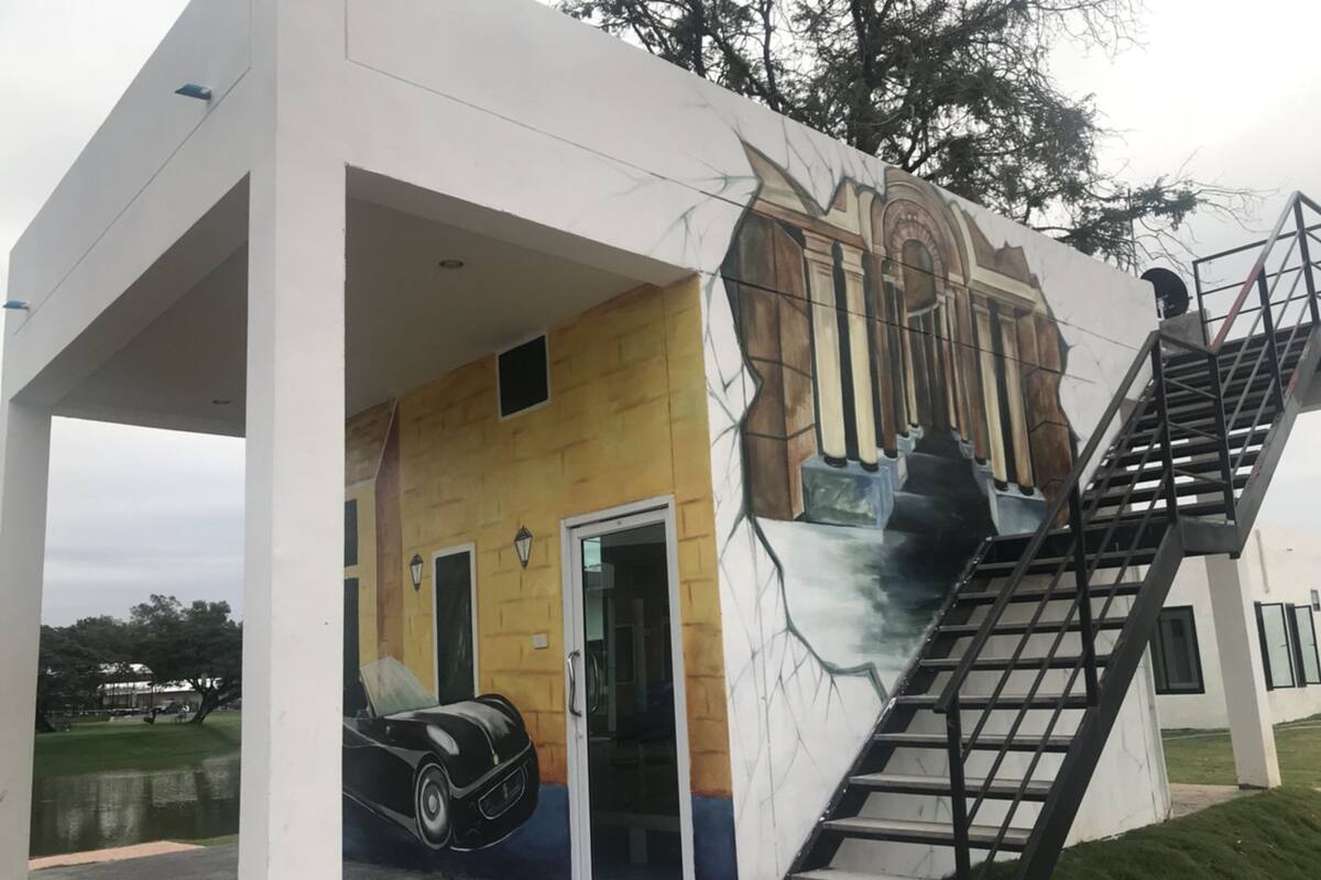 A building with a mural of a car and a staircase leading to an upper level.