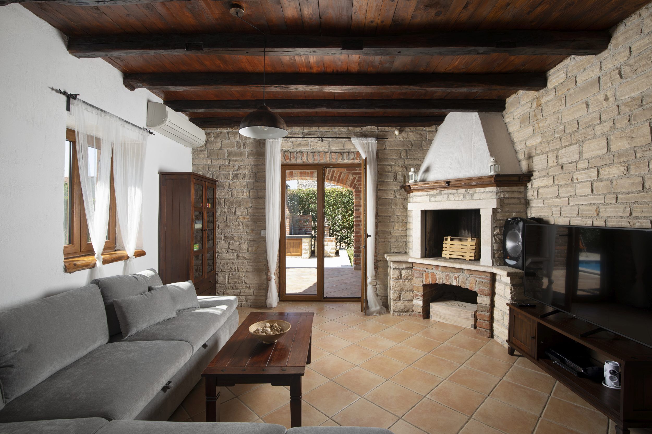 A living room with a sofa, a wooden table, a television, and a fireplace.