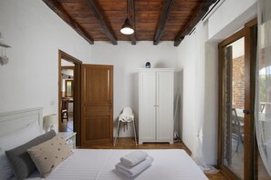 A bedroom with a bed, a white wardrobe, a baby changing station, and a view through a glass door. - Villa Orlene in Paradis (Svetvinčenat)