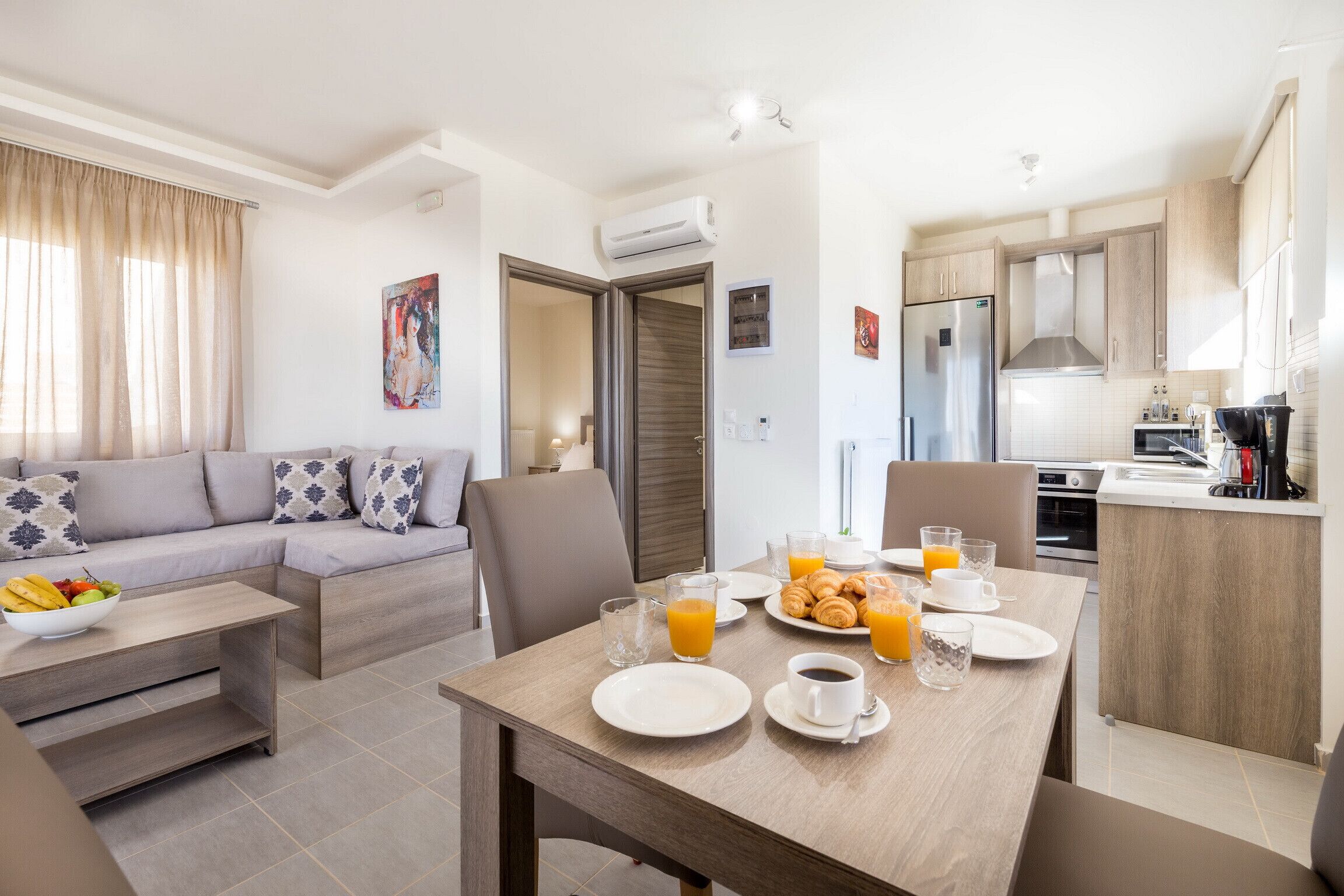 A modern living room with a sofa, dining table, and breakfast setup.