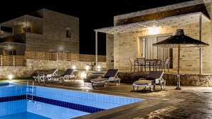Zona de piscina con sillas de descanso y una pérgola.