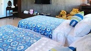 A bedroom with two beds, a flat-screen TV mounted on the wall, and a desk with a chair. - Tomato Coffee BnB (Taitung)