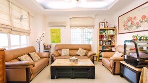 A living room with two sofas, a coffee table, a television, and a bookshelf. - Tomato Coffee BnB (Taitung)