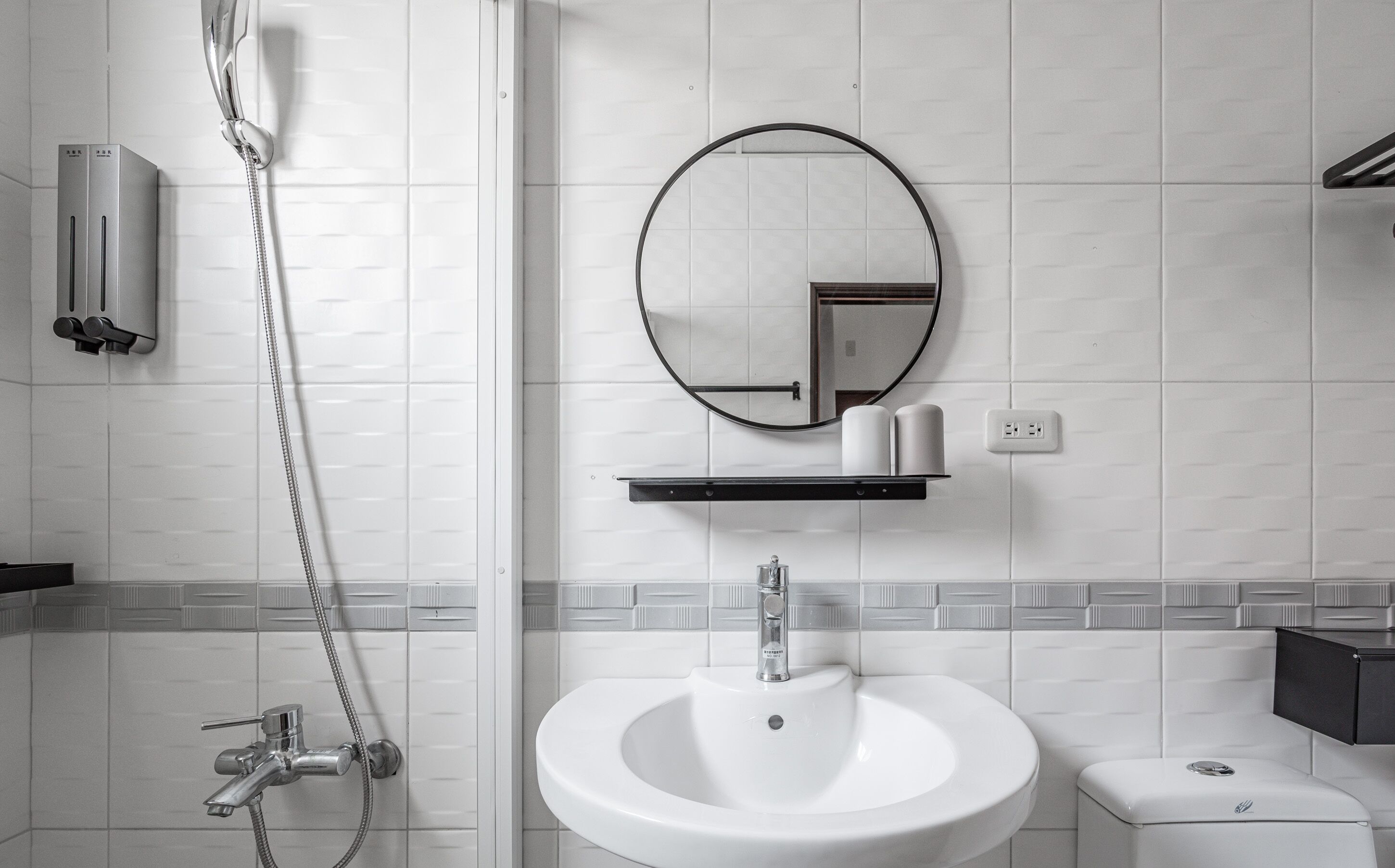 Un baño moderno con ducha, lavamanos e inodoro.