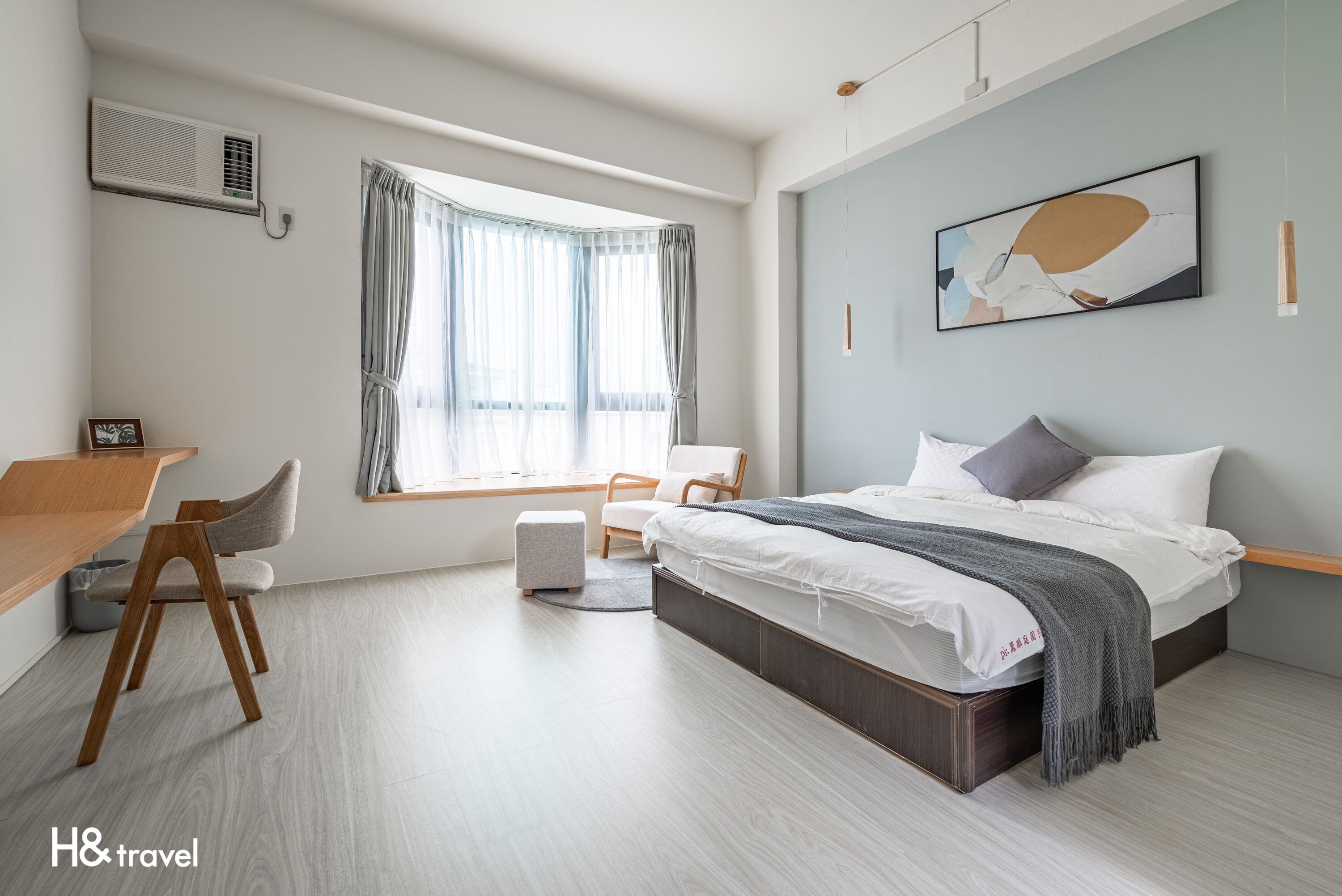 Una habitación de hotel moderna con una cama, un escritorio y una silla.