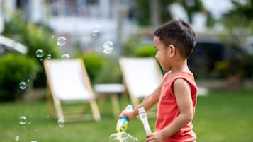 A child playing with bubbles outdoors.