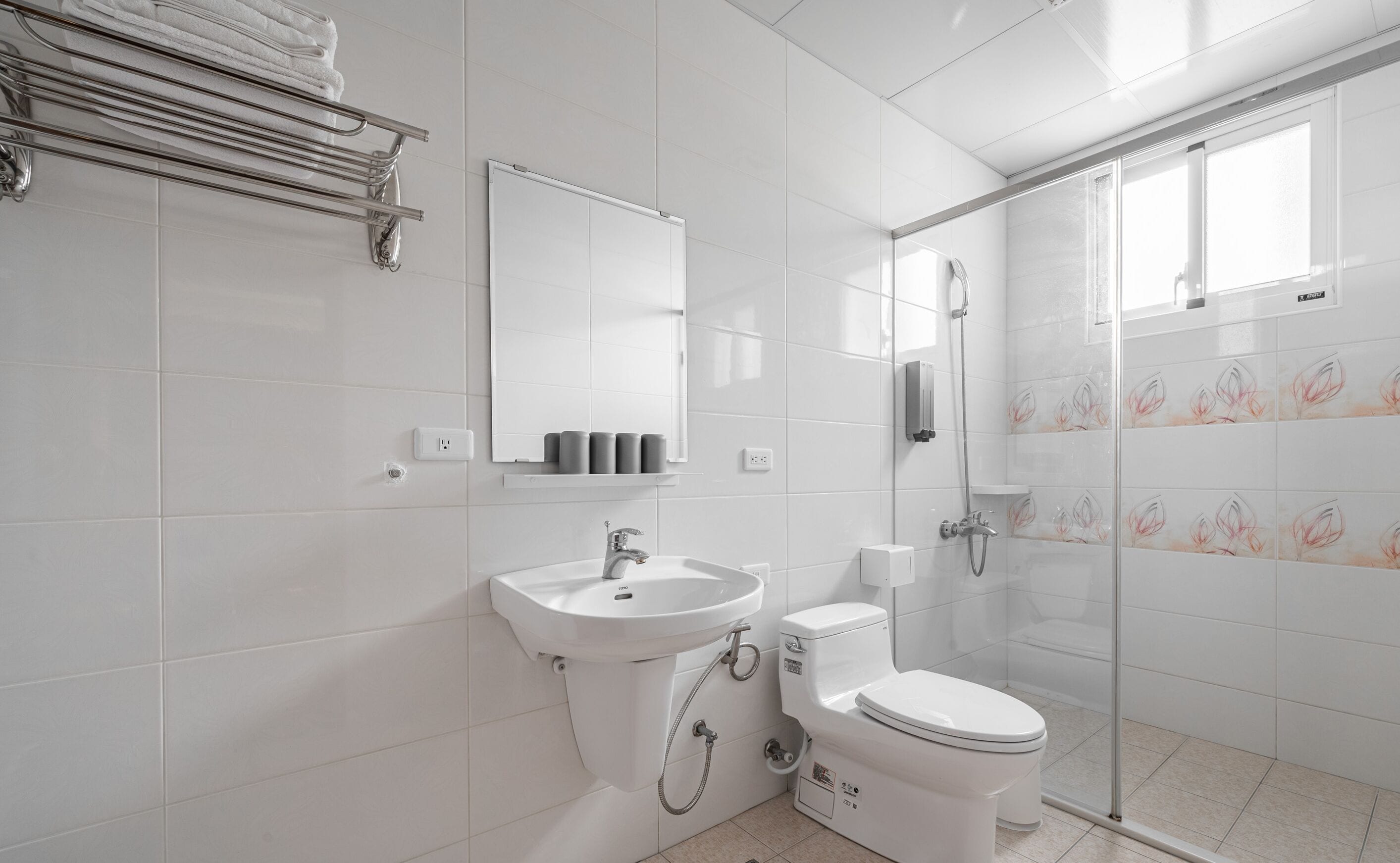 Un baño moderno con lavamanos, inodoro y ducha.