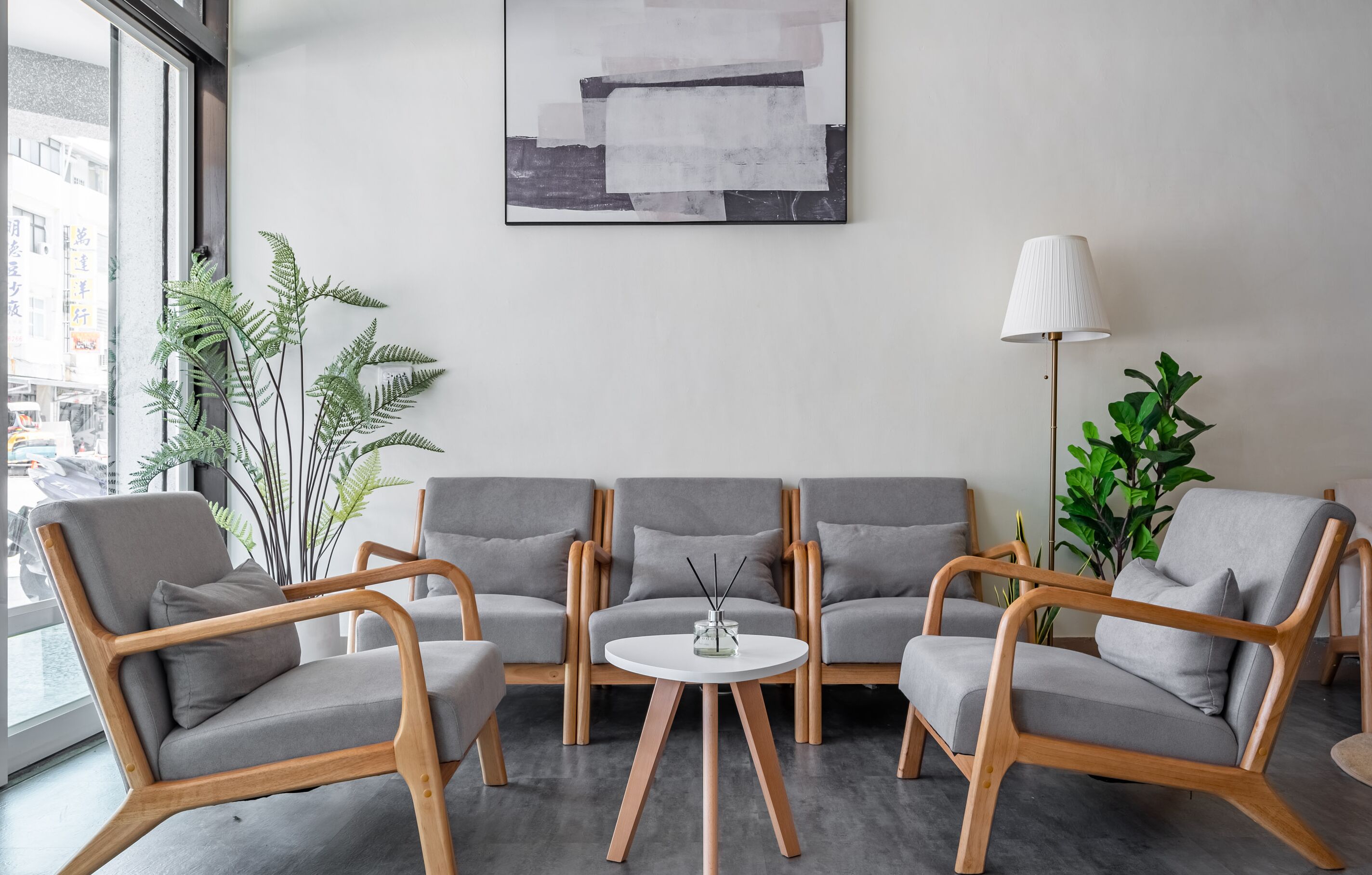 A modern living room with grey sofas, a round coffee table, and a floor lamp.