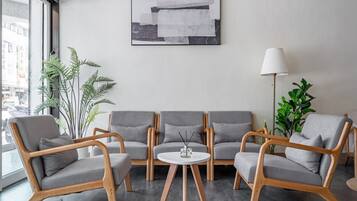A modern living room with grey sofas, a round coffee table, and a floor lamp.