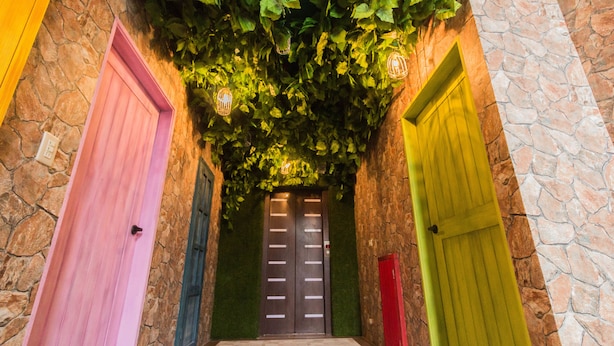 A hallway with three doors, each in a different color. - Alice Wonderland B&B (Dongshan)
