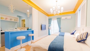 A modern hotel room with a large bed, a small desk, and a bar area. - Alice Wonderland B&B (Dongshan)
