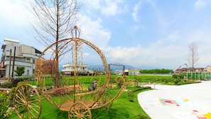A large, ornate carriage in a park setting with buildings in the background. - Alice Wonderland B&B (Dongshan)