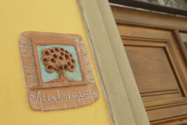 A building corner with a yellow wall and a door. There is a plaque with a tree design and the text 'Villa Luise Eber' on the wall. - 3BR-3BA apt, walk to downtown Cortona, with airco, wifi and amazing view (Cortona)